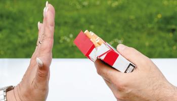 Mano de mujer rechaza un cigarrillo servido en una caja.